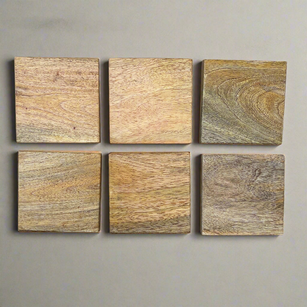 six square wooden tiles with different wood grain patterns arranged in a grid on a grey wooden surface.