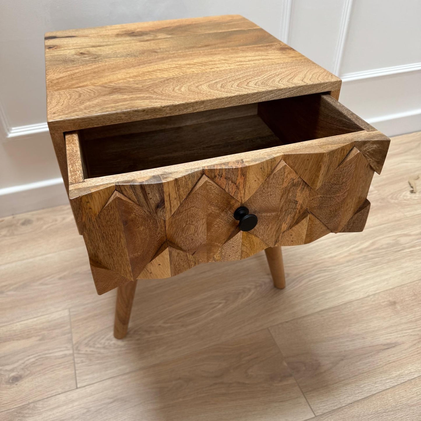 Wooden nightstand with geometric design on a wooden floor