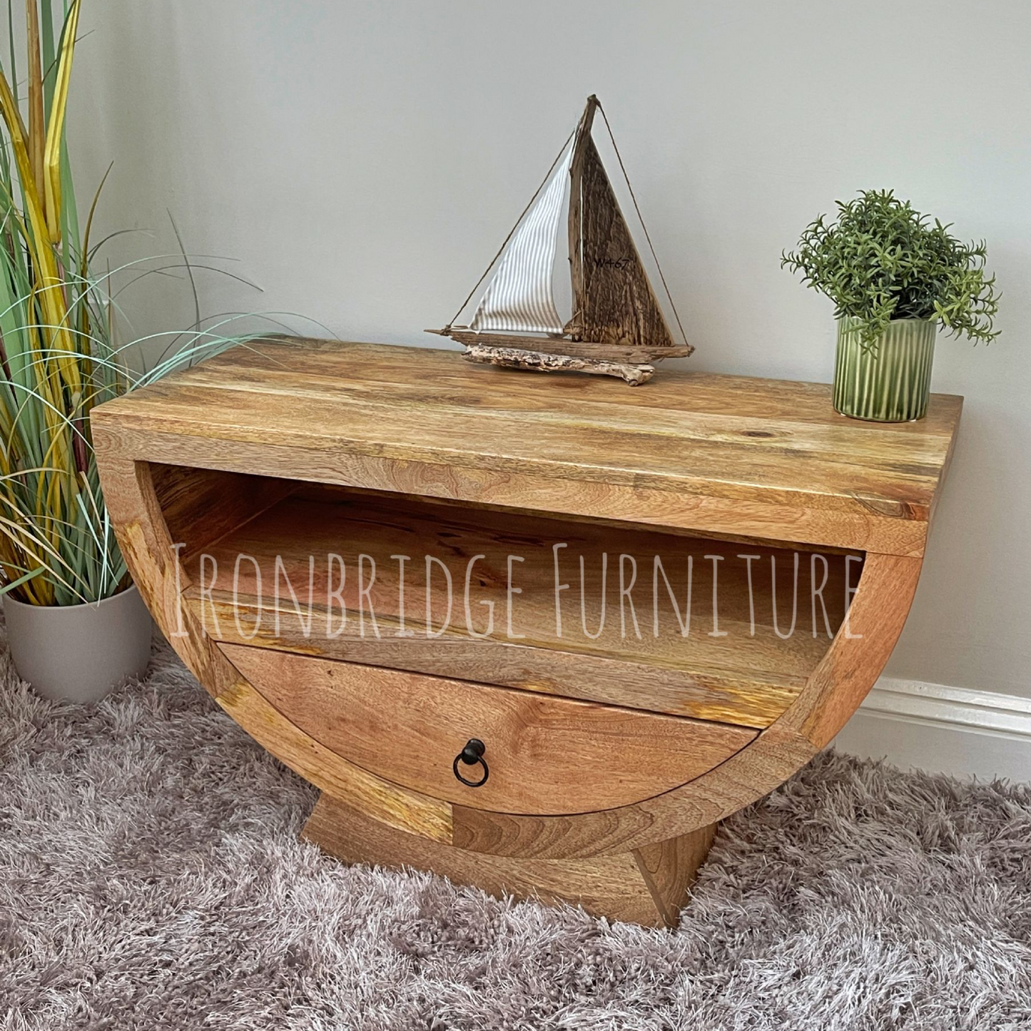 Mango wood half moon shaper TV small sideboard in a room setting at an angle