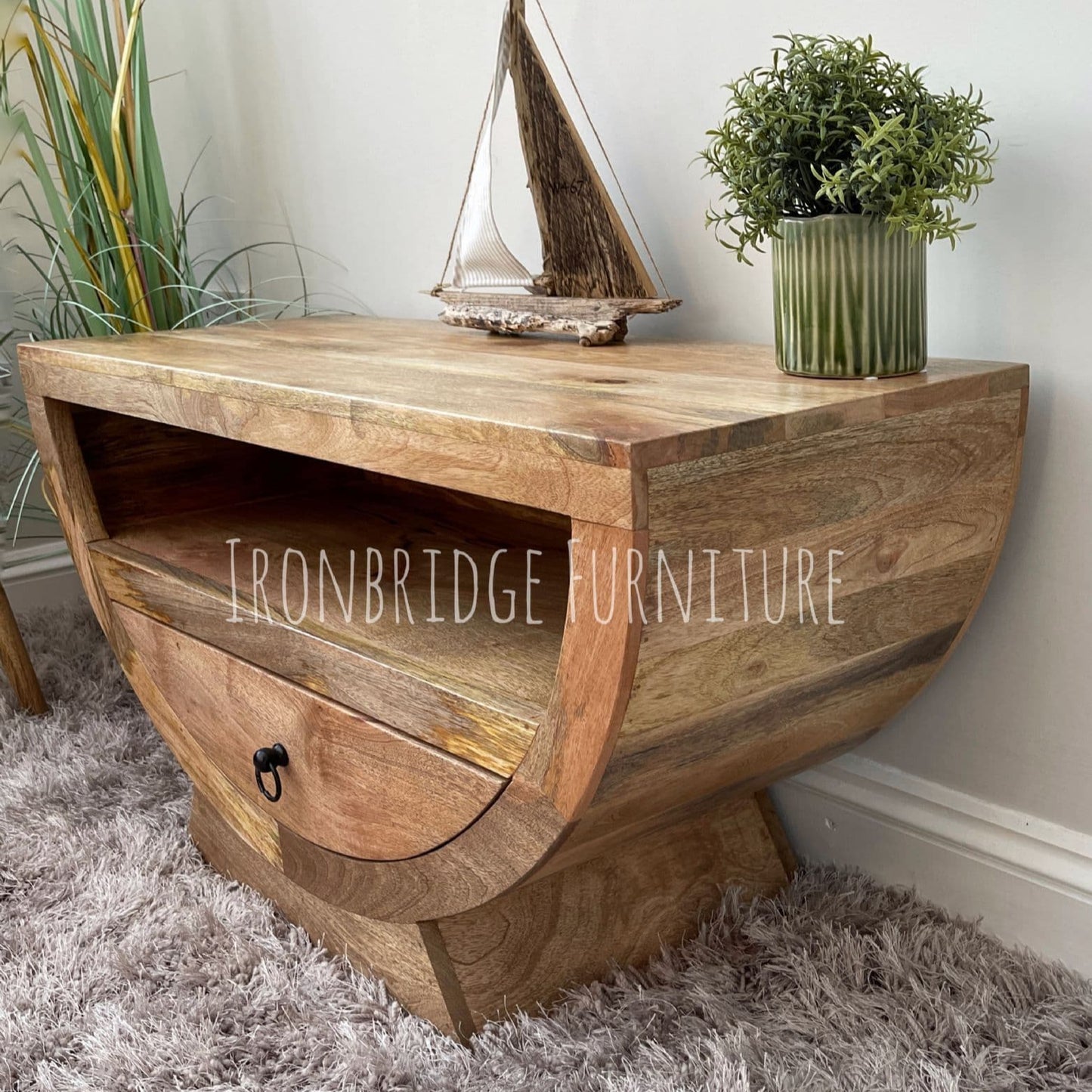 Mango wood half moon shaper TV small sideboard in a room setting at an angle close up