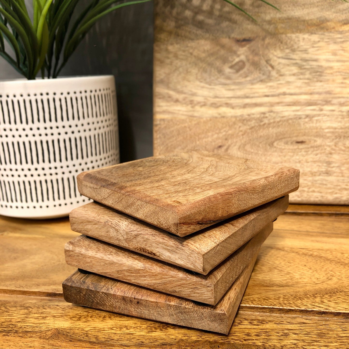 Set of Solid Mango Wood Board Placemats and Coasters. Close up of four coasters.