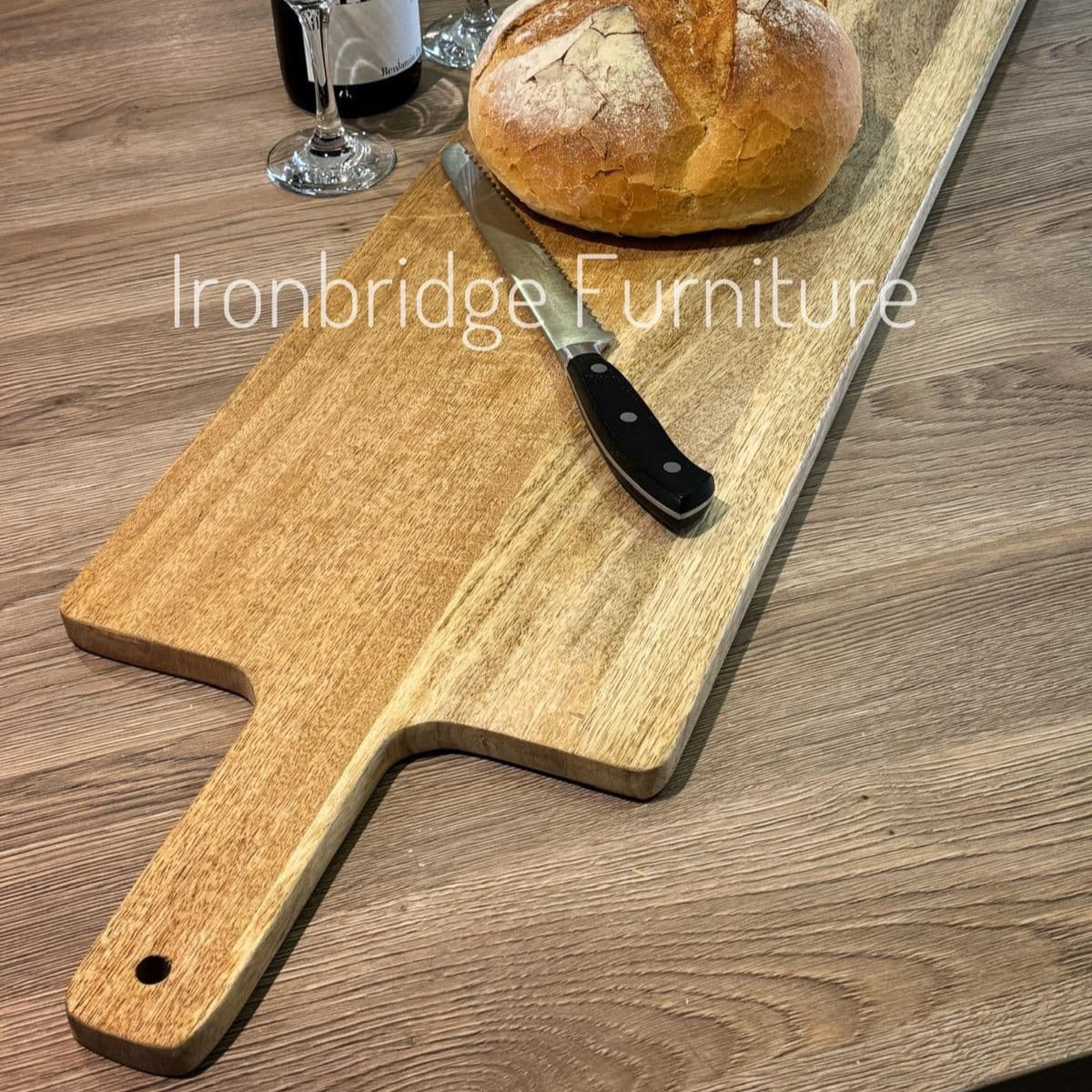 Extra long Mezzo Charcuterie board on a work surface with a loaf of bread