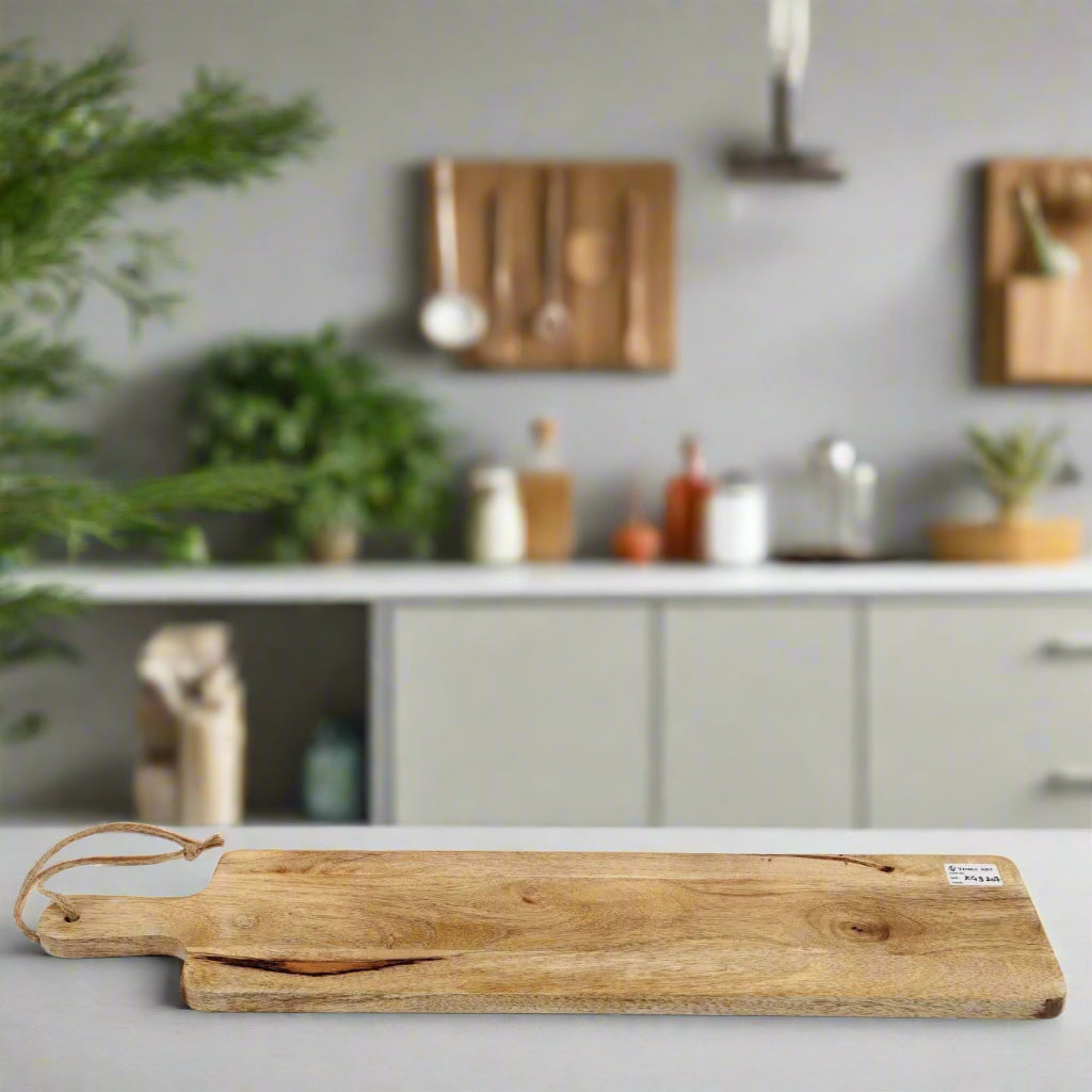 Long slim Mango wood paddle grazing board on a worktop