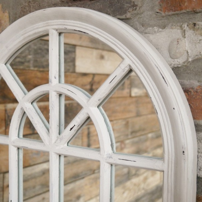 Round white window frame against a brick wall