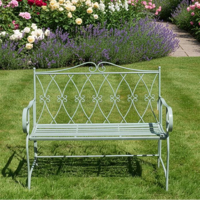 Wrought iron bench in a garden with a fountain in the background