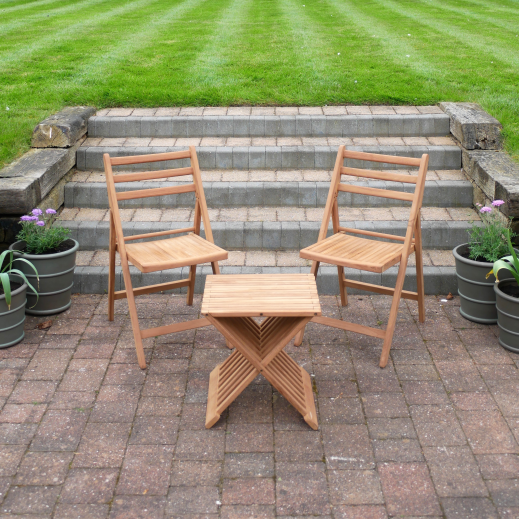 Outdoor patio with wooden chairs and table in a garden setting