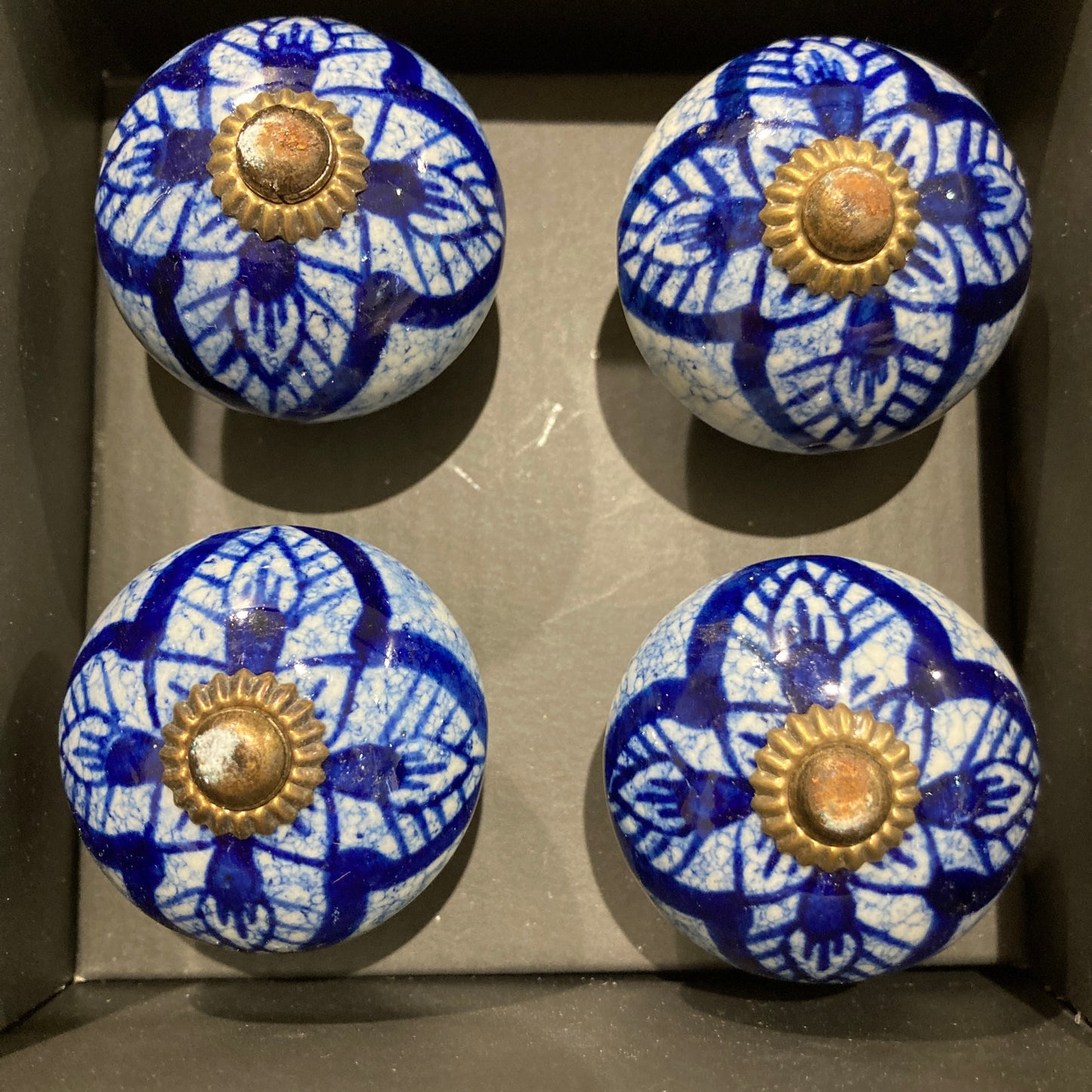 Set of 4 hand painted ceramic knob handles. Blue pattern in box.