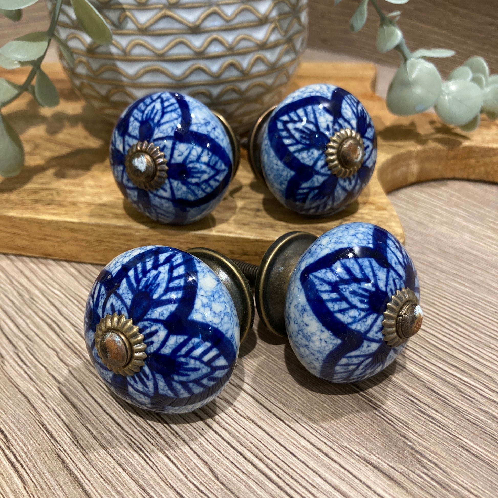 Set of 4 hand painted ceramic knob handles. Blue pattern pointed outwards. 