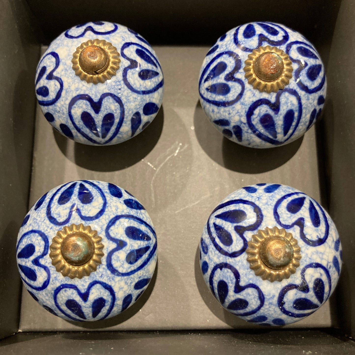 Set of 4 hand painted ceramic knob handles. Heart pattern in box.