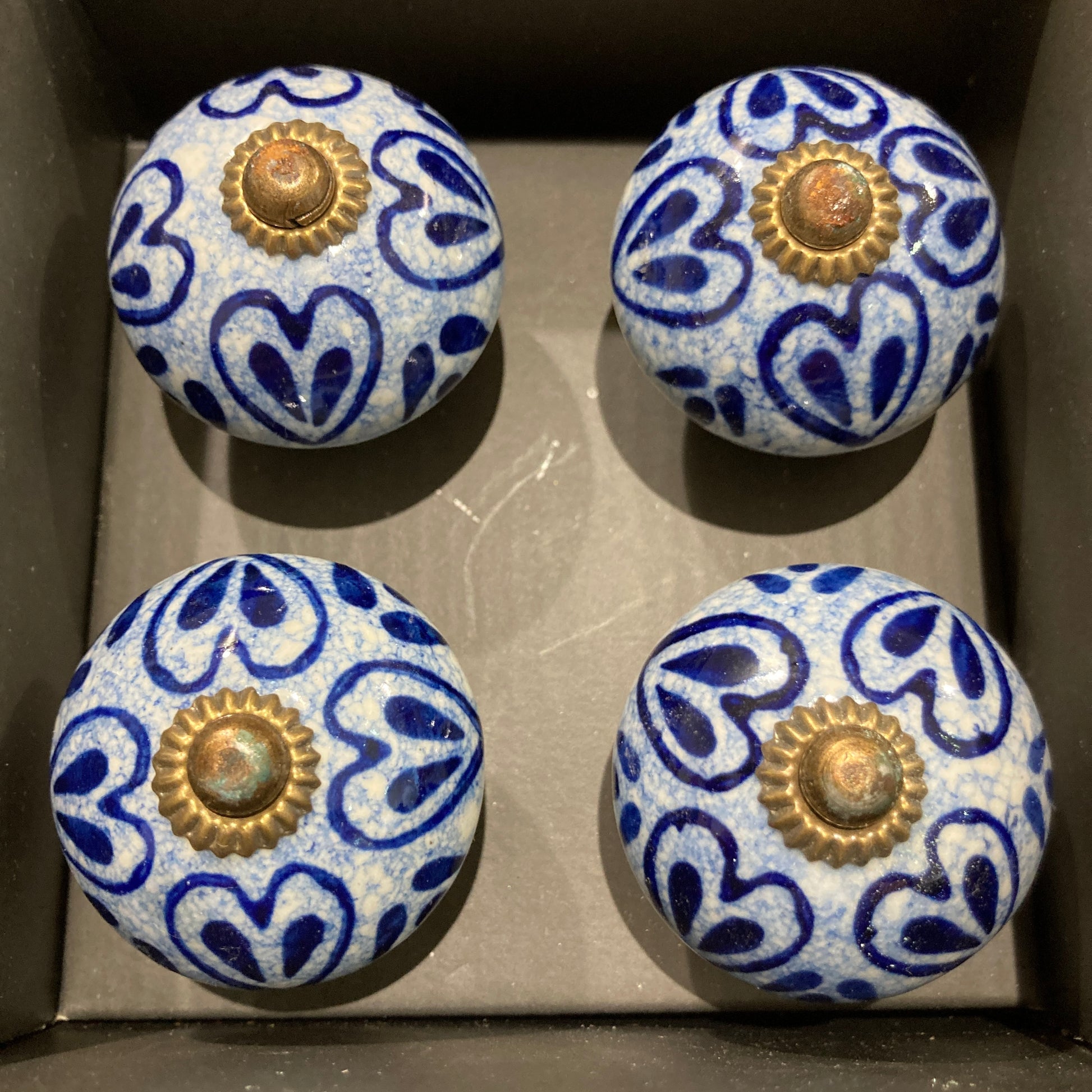 Set of 4 hand painted ceramic knob handles. Heart pattern in box.