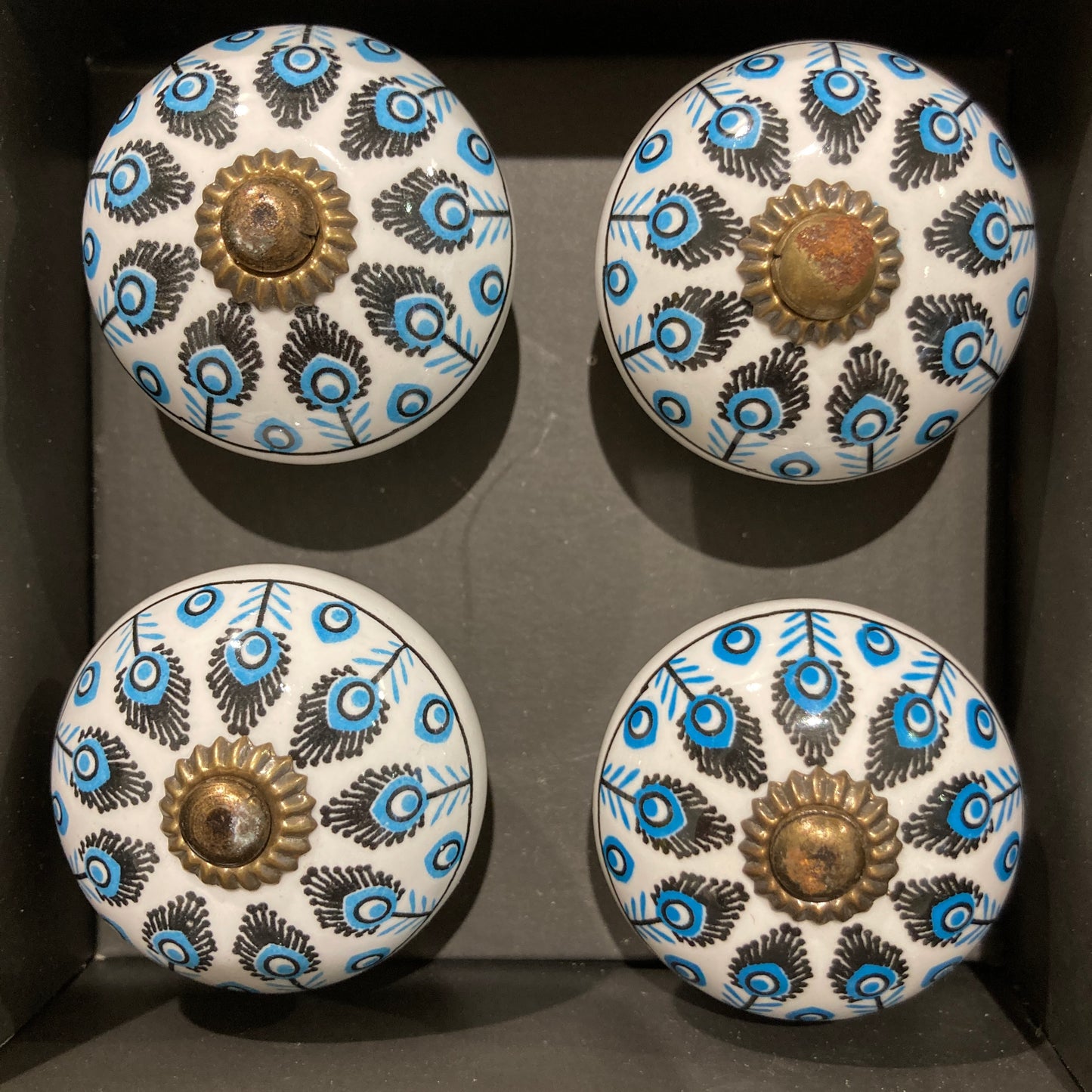 Set of 4 hand painted ceramic knob handles. Feather pattern in box.