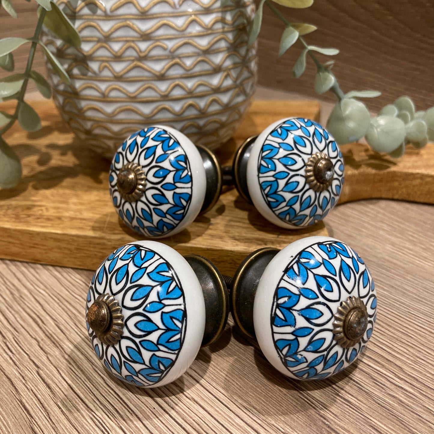Set of 4 hand painted ceramic knob handles - blue and white design pointing outwards.