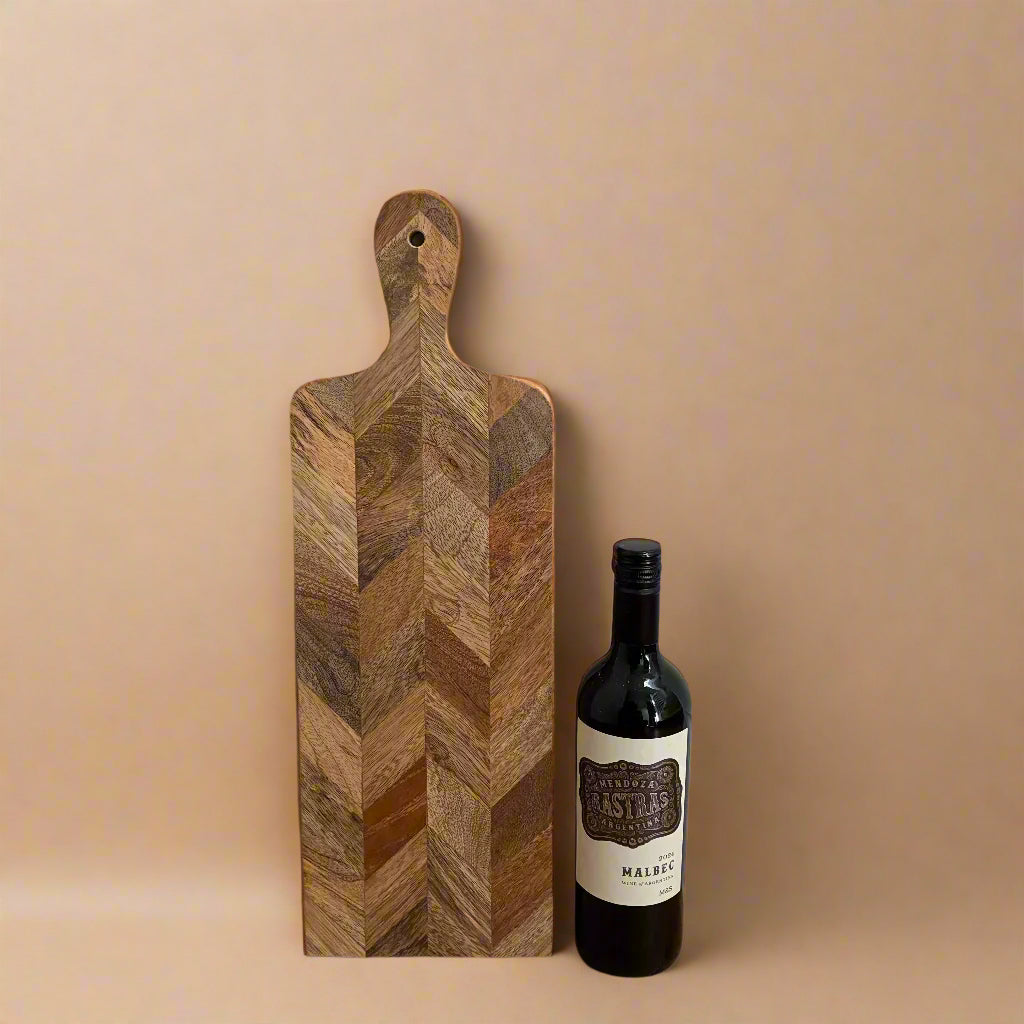 Wooden cutting board with a bottle of wine on a beige background