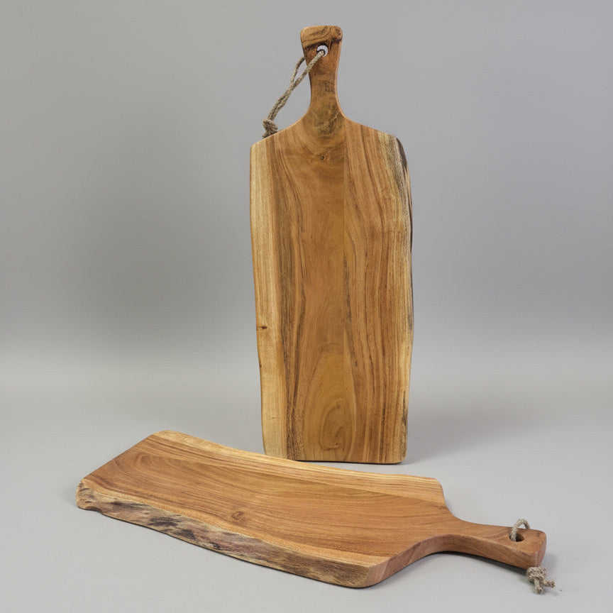 Wooden cutting boards on a pallet with cardboard boxes in the background