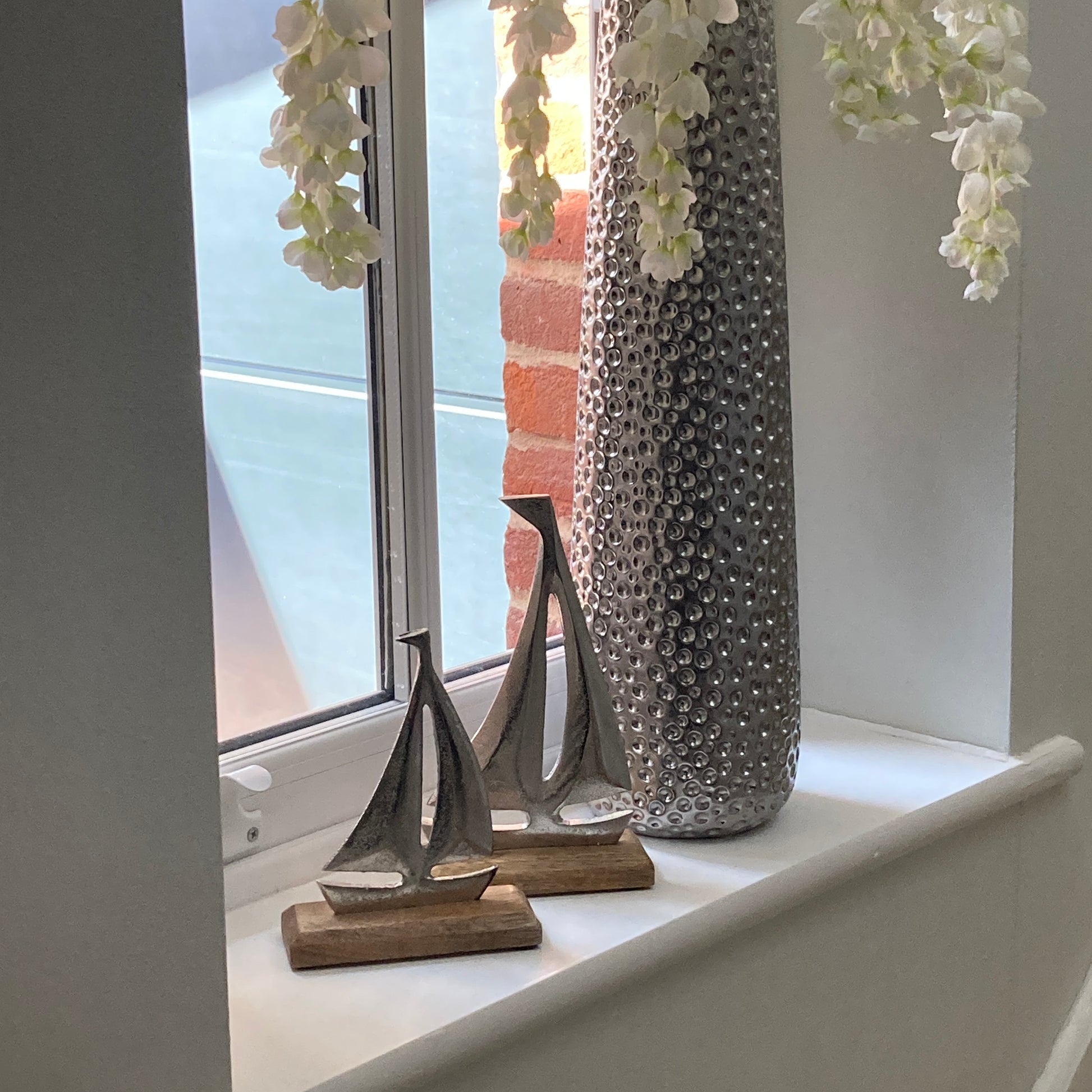 Cast aluminium sailing yachts on Mango wood base. 2 sizes available. Displayed on a windowsill. 
