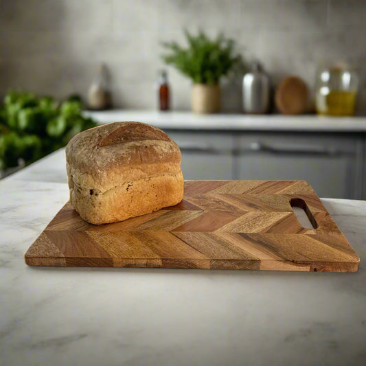 Loaf of bread on a wooden cutting board in a kitchen