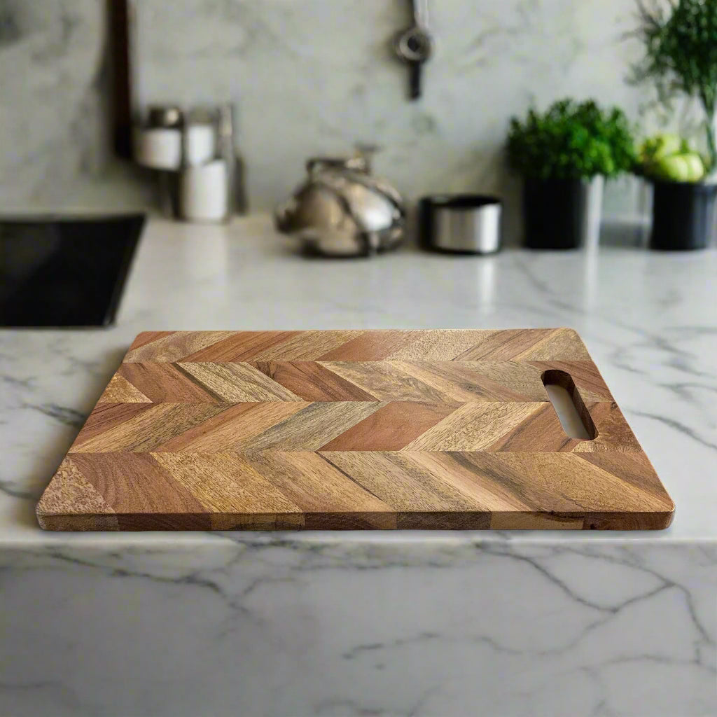 Wooden cutting board with a chevron pattern on a marble countertop