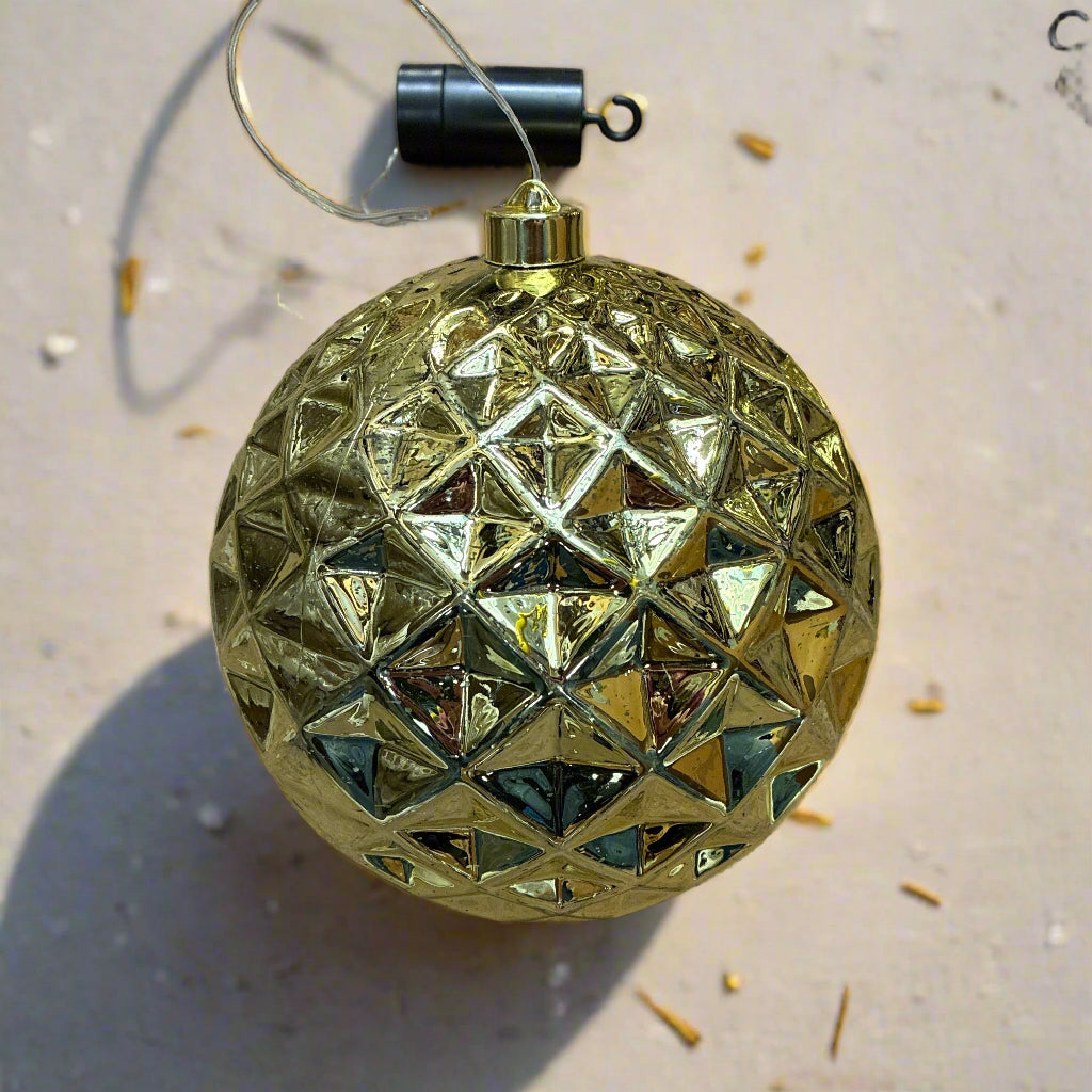 Gold geometric Christmas ornament on a brown surface