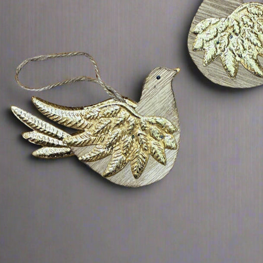 Two decorative bird ornaments on a textured surface