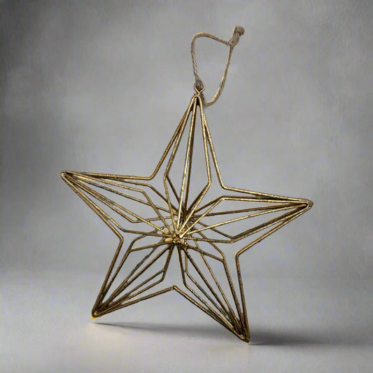 Gold geometric star ornament on a gray background