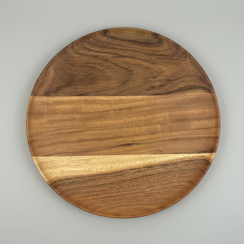 Round wooden cutting board on a gray surface