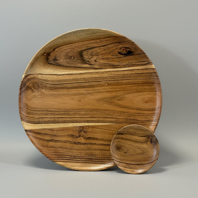 Round wooden cutting board with a smaller round piece on a neutral background