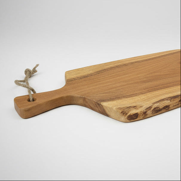 Wooden cutting board with a handle on a light gray background