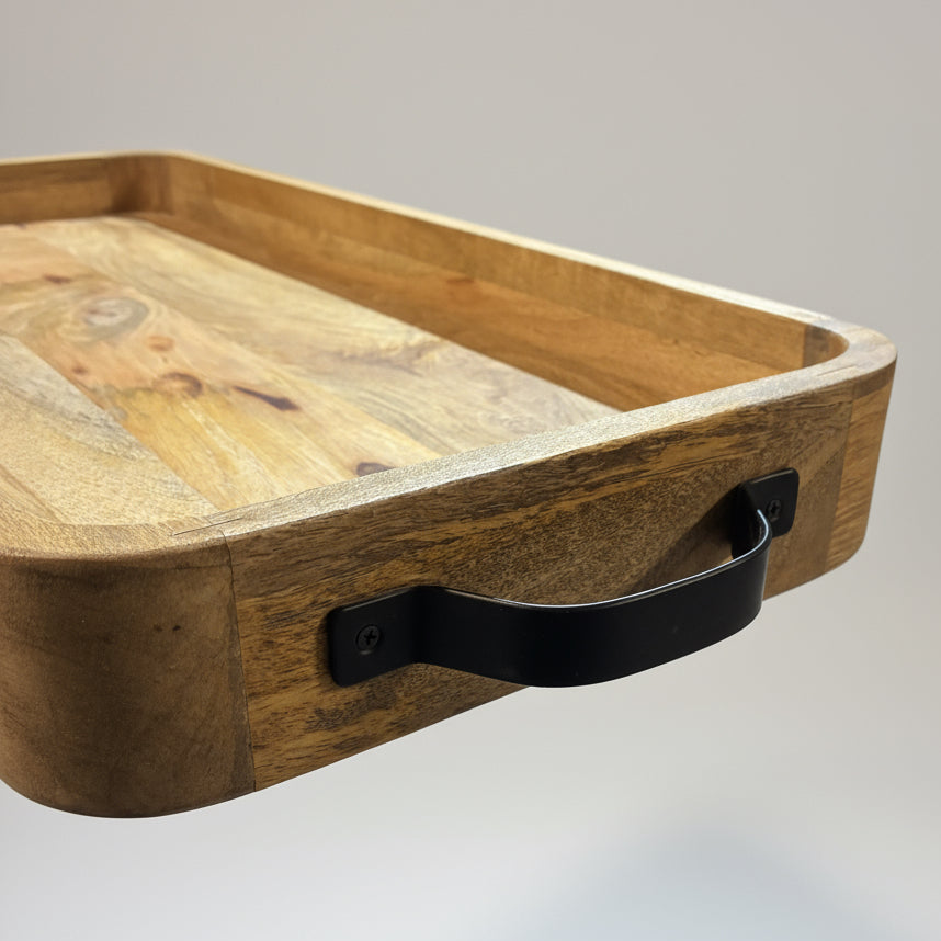 Wooden tray with a black handle on a light gray background