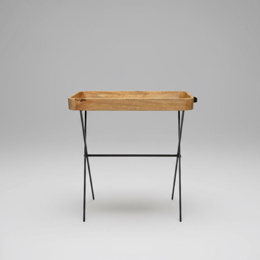 Bottle of Gin on a wooden tray in a garden setting with people in the background