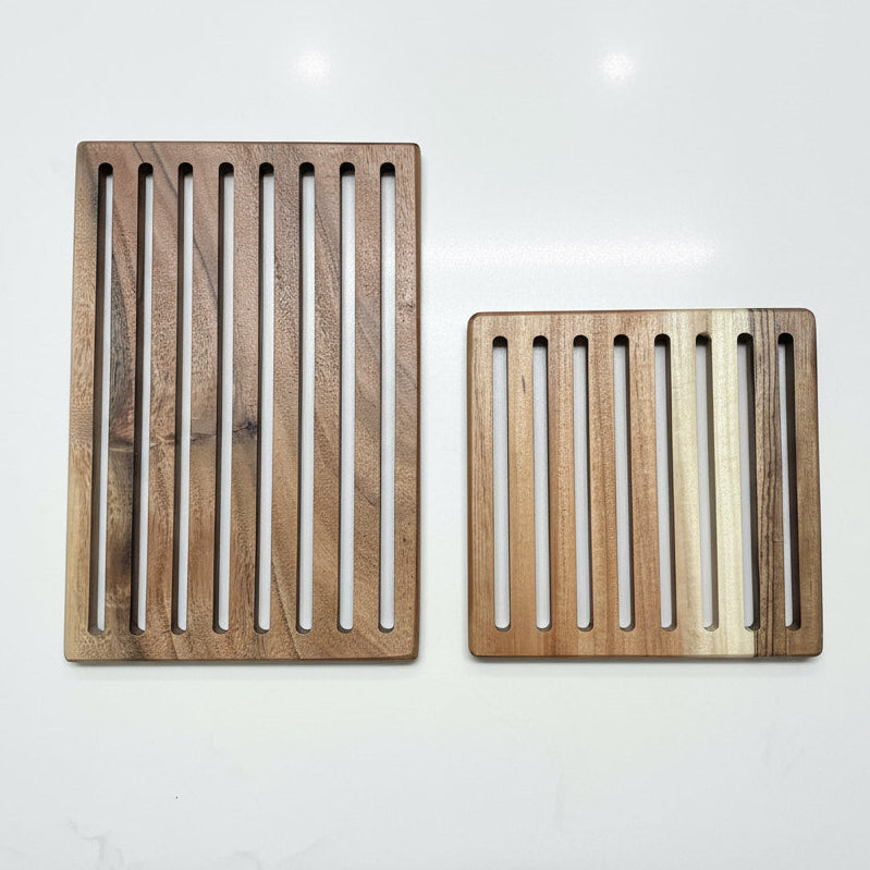 Two wooden slotted trays on a concrete surface