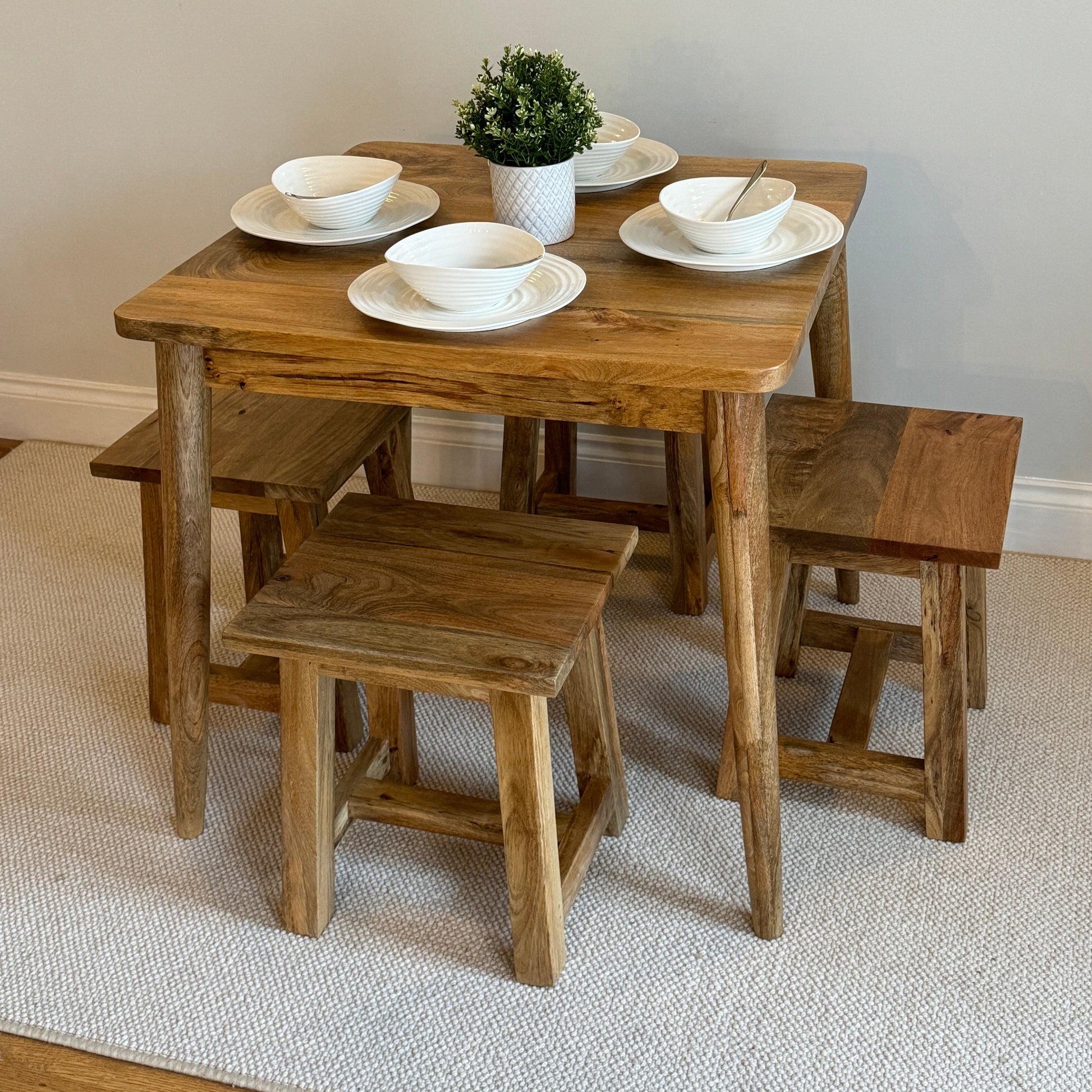 80cm Square Mango dining table with cone shaped legs dressed with 4 settings with 4 stools