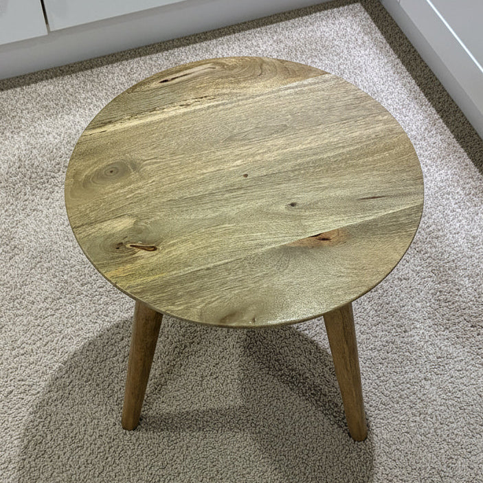 Wooden stool on a tiled floor with white cabinets in the background
