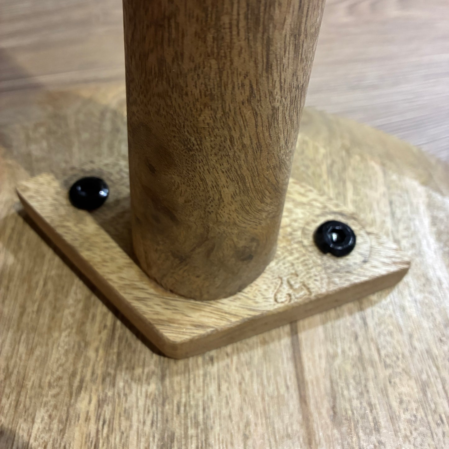 Wooden leg with metal screws on a wooden surface