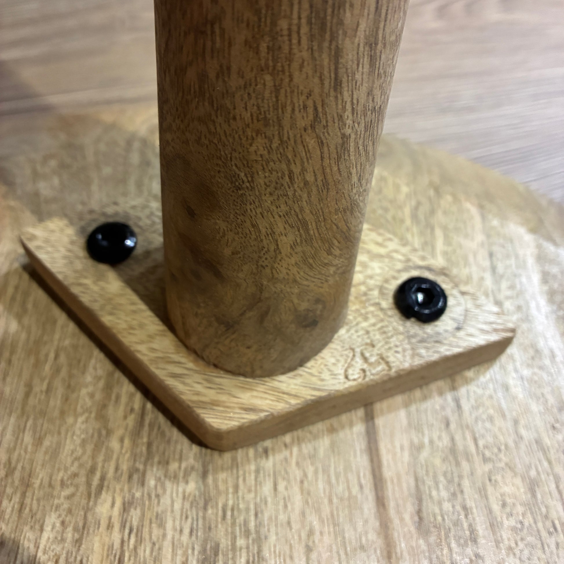 Wooden leg with metal screws on a wooden surface