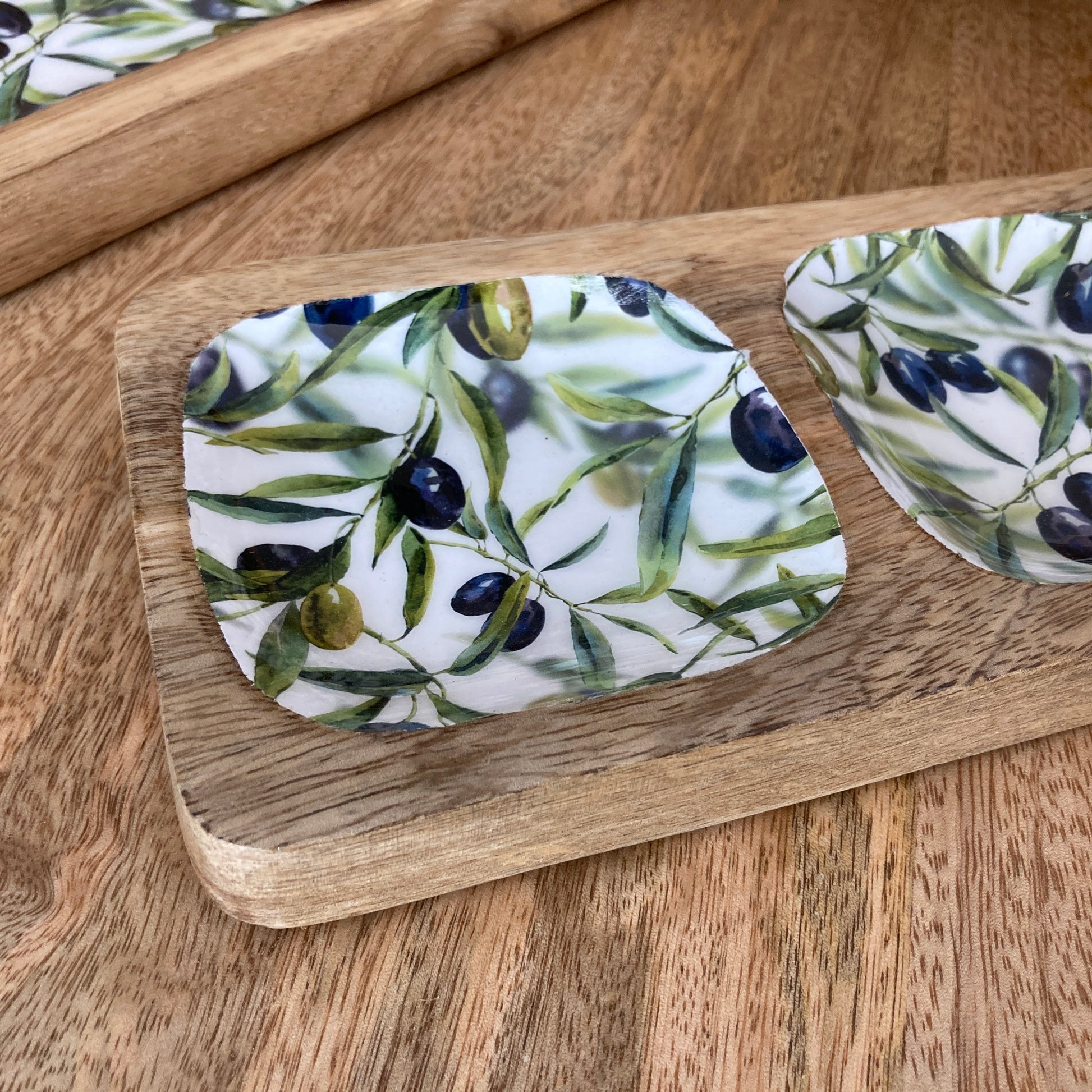 close up picture of nibbles dish with olive design on a wooden tray