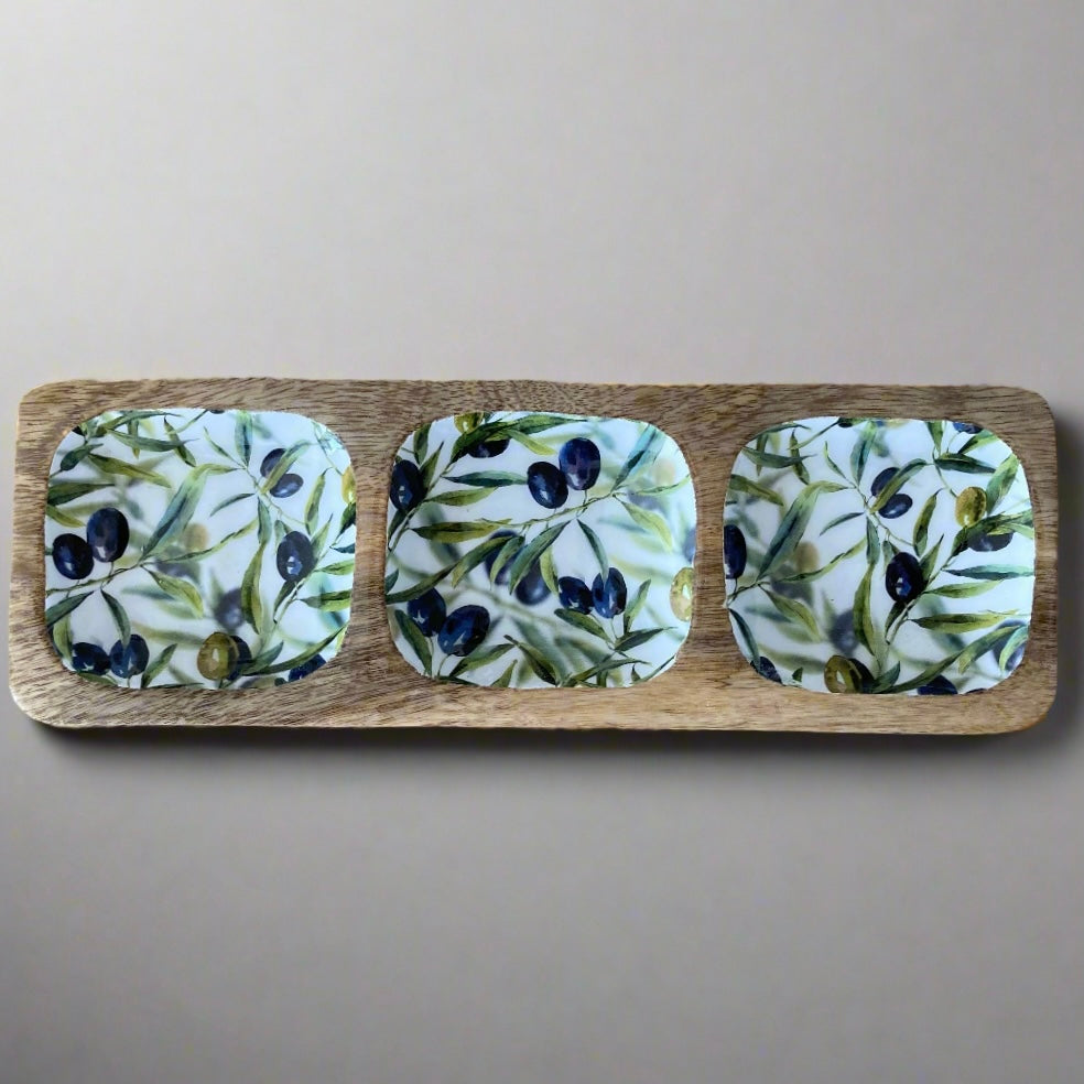 Tripple section dish with olive design on a wooden board against a beige background