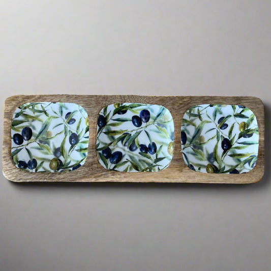 Tripple section dish with olive design on a wooden board against a beige background