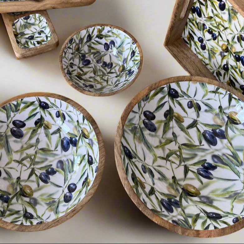 Set of enamelled wooden dishes with olive branch pattern on a white surface