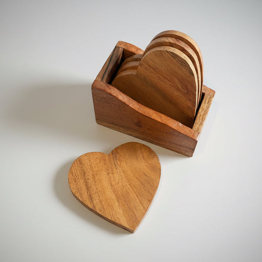 Wooden heart-shaped coasters in a wooden holder on a gray surface