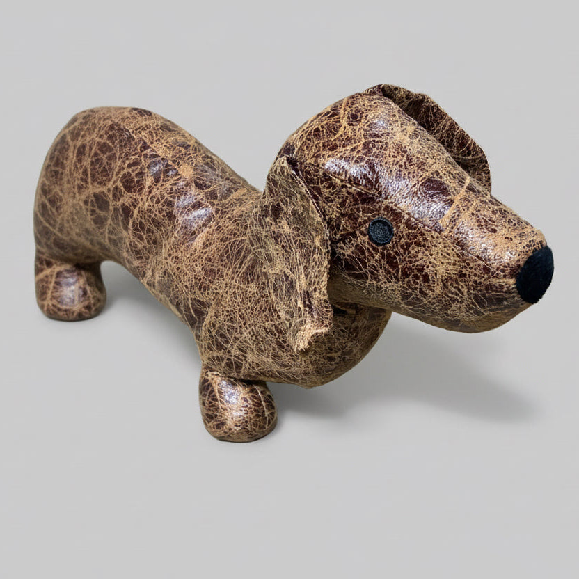 Brown textured dog-shaped object on a concrete surface