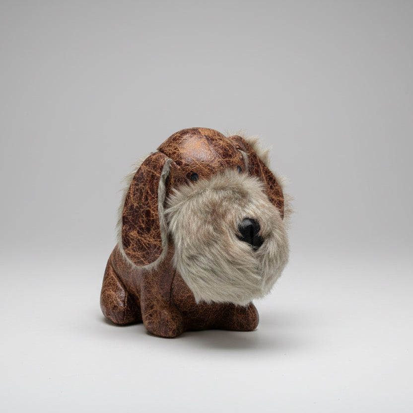 Plush toy resembling a sloth on a concrete surface