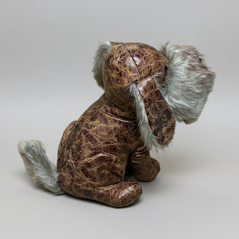 Brown plush dog toy with gray fur on a concrete surface
