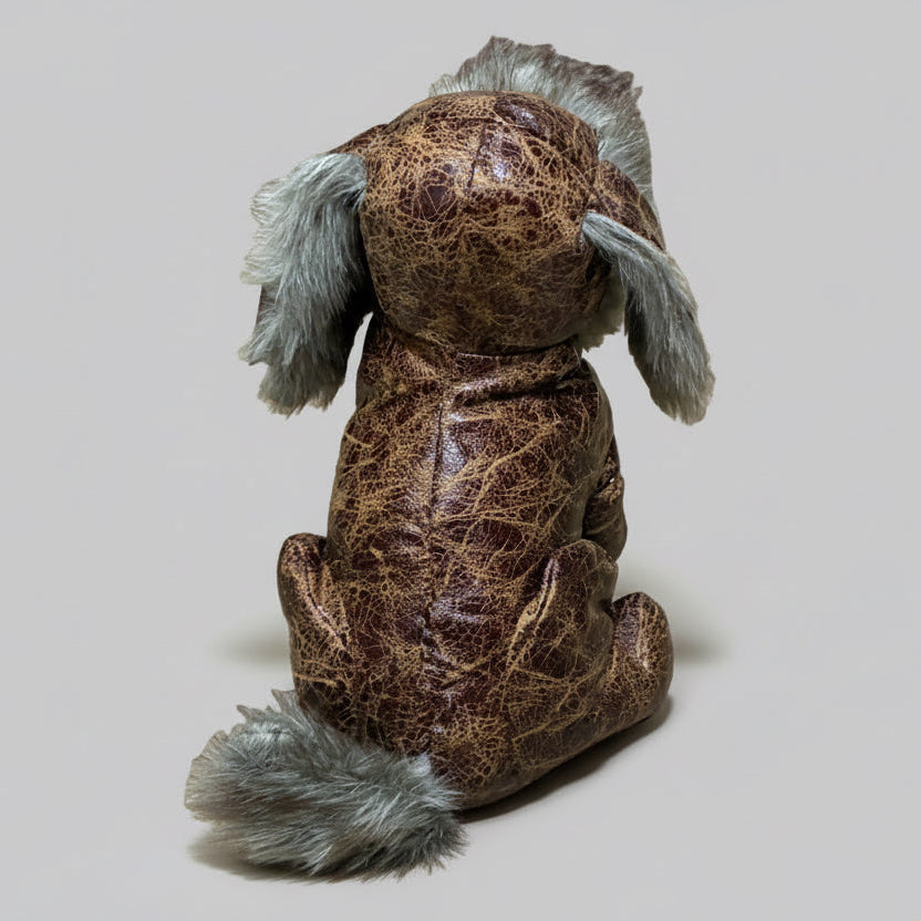 Brown textured dog toy with gray fur on a concrete surface