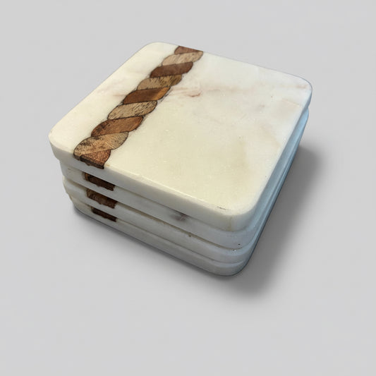 Set of marble coasters with woven wood design on a gray surface