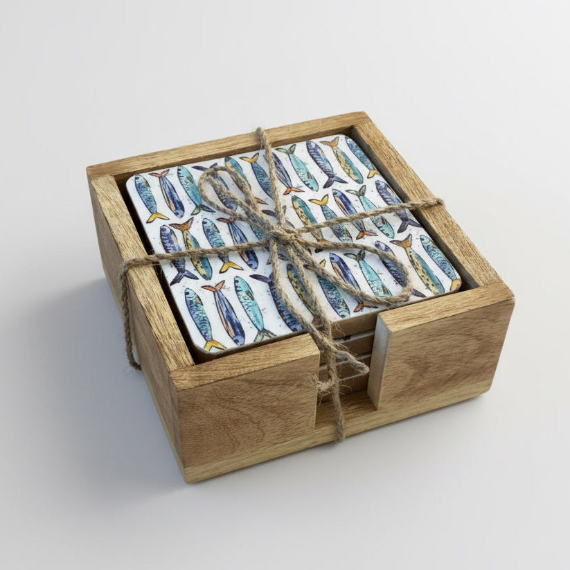 Set of coasters with fish pattern in a wooden box on a wooden surface