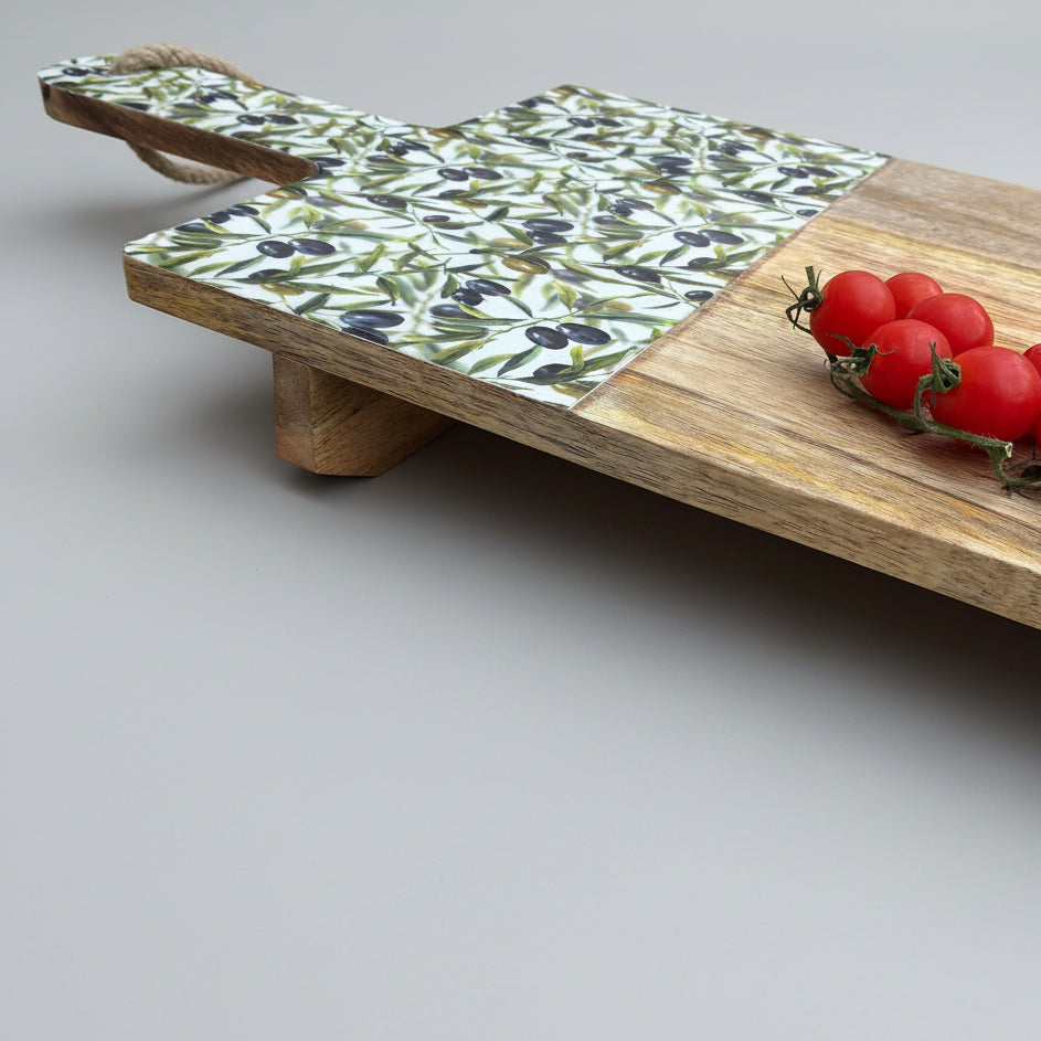 Wooden tray with floral patterned end and tomatoes on a wooden floor