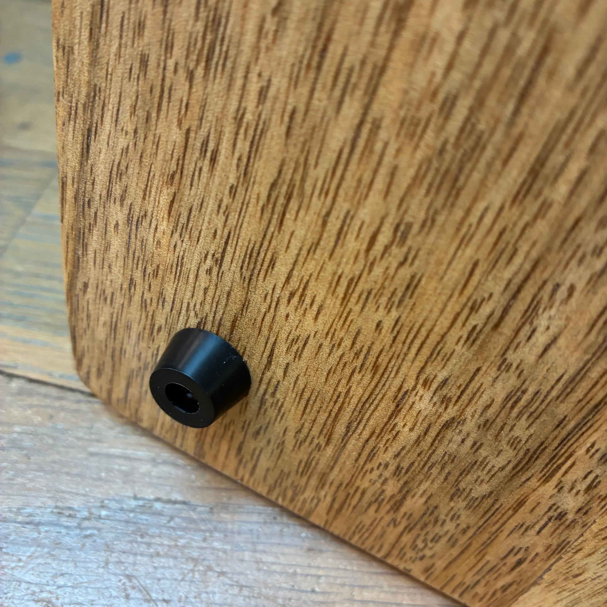 Close-up of a wooden surface with a black cylindrical object on it