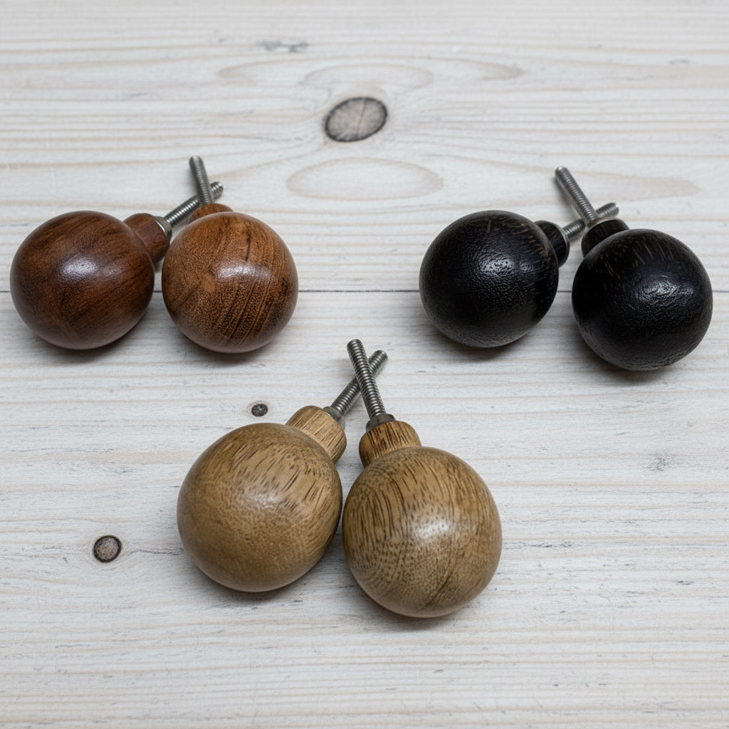 Wooden and black spherical objects with metal stems on a textured surface
