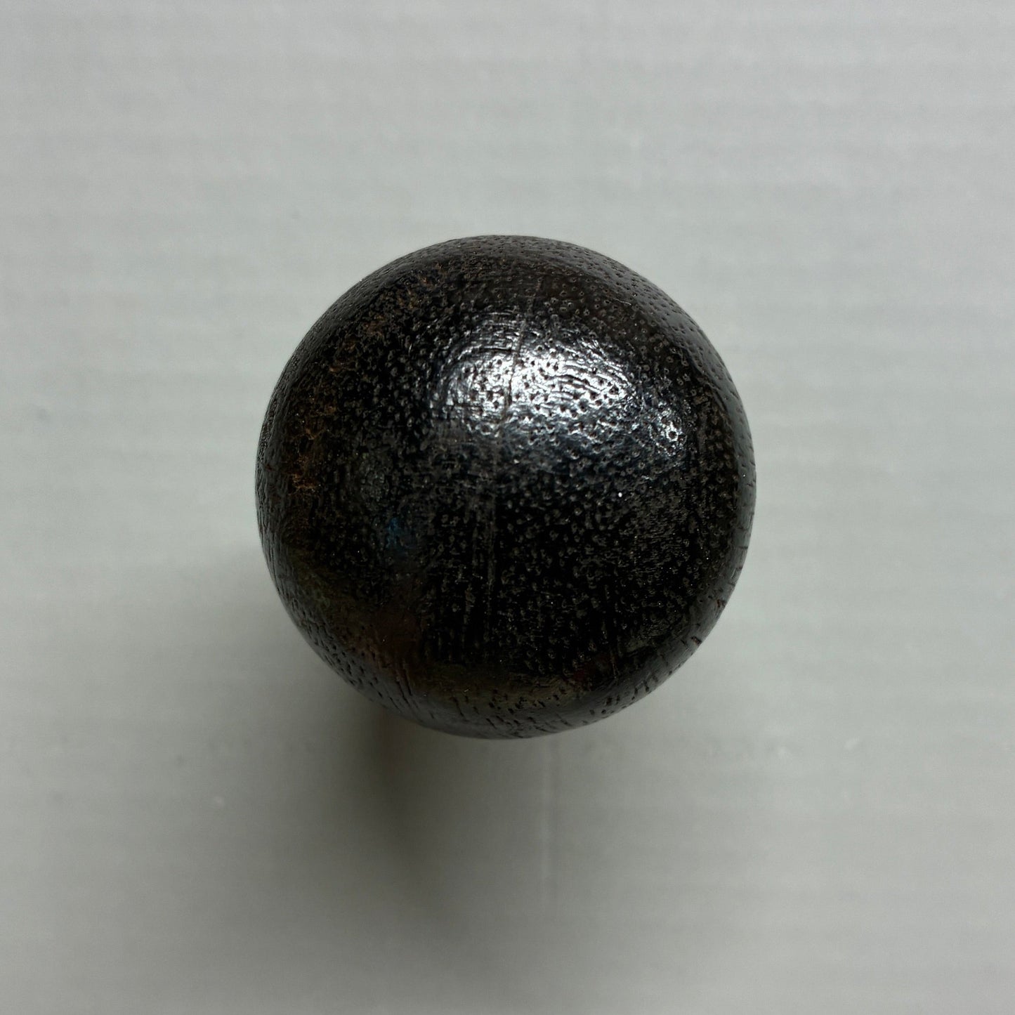 Black spherical object on a white background