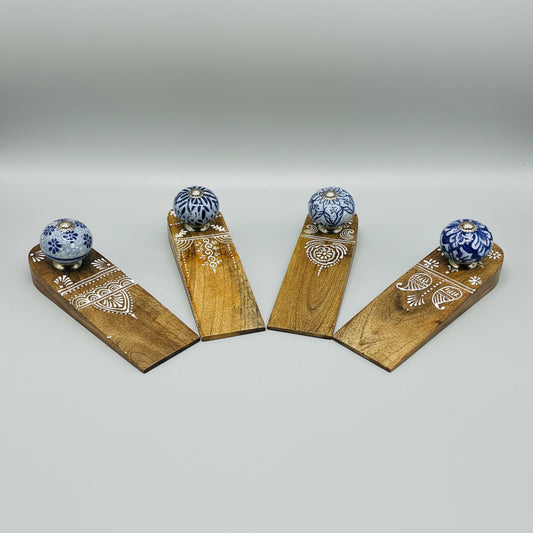 Wooden doorstops with blue floral designs on a black background